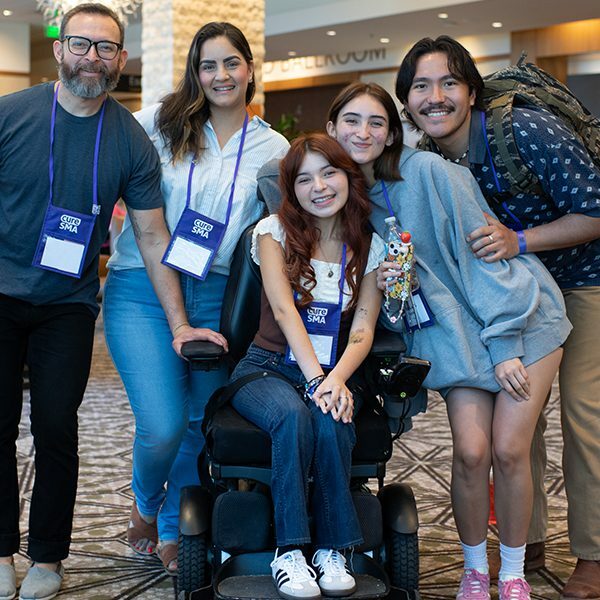 Family posing for a picture with a daughter that has SMA.