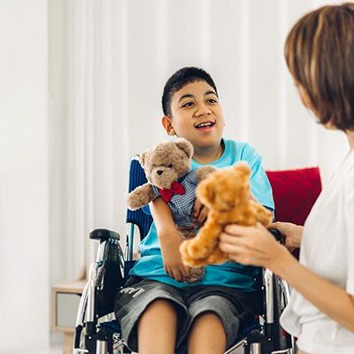 Young man in a wheelchair talking with a nurse.